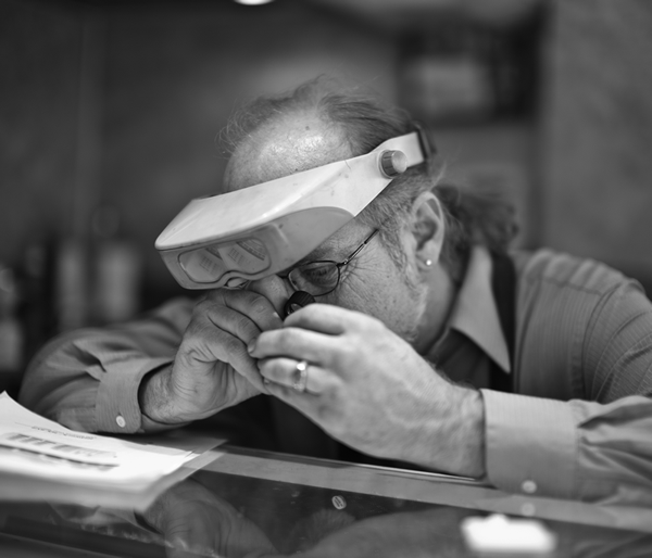 Lane Mitchell, Master Jeweler, examining jewelry